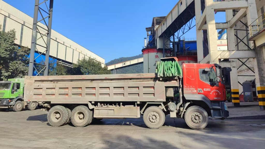 A transport truck waiting in the loading area of a cement plant for material dispatch
